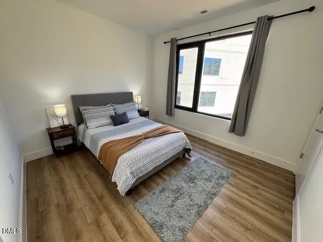 a bedroom with a bed lamp and a large window