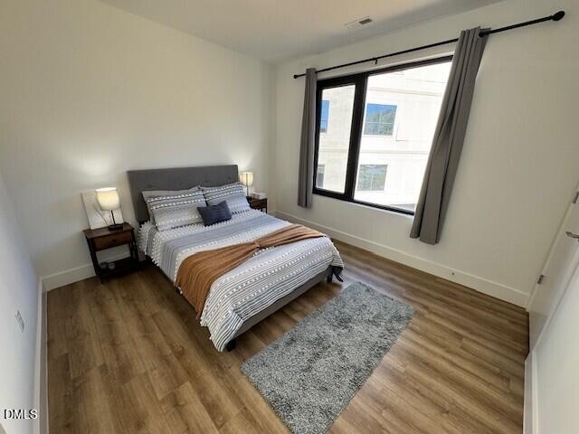 1115 Nova Street Durham, NC 27713 - Photo 10 of 24 a bedroom with a bed lamp and a large window