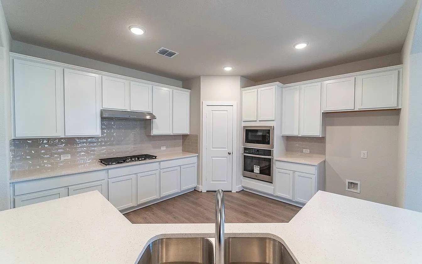 450 Durian Loop Buda, TX 78610 - Photo 2 of 17 Sleek counters and integrated appliances define this well-appointed culinary space.