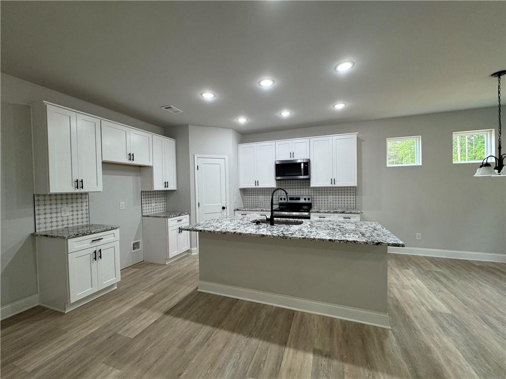 2057 North Hicks Road Toccoa, GA 30577 - Photo 11 of 22 a kitchen with stainless steel appliances granite countertop a stove sink and cabinets