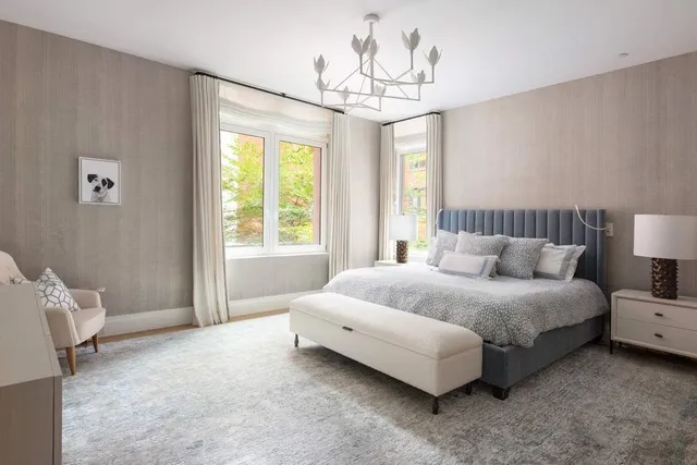 a spacious bedroom with a bed and a chandelier