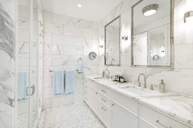 a bathroom with a double vanity sink mirror and shower