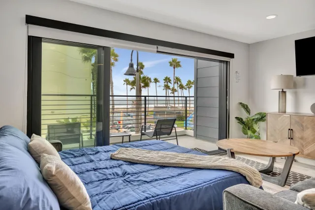 a living room with couches and kitchen view with wooden floor