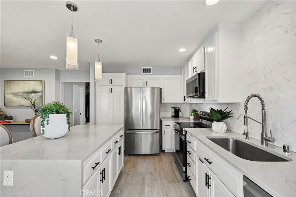 a kitchen with kitchen island a sink appliances and cabinets