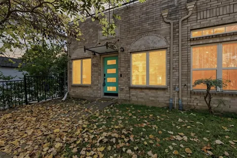 a view of a house with a small yard and wooden fence