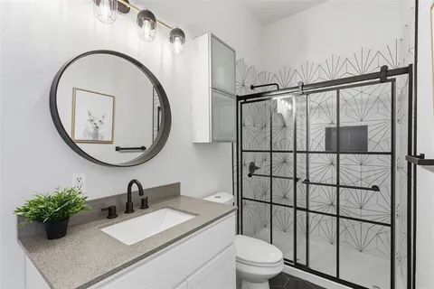 a bathroom with a toilet a sink and mirror