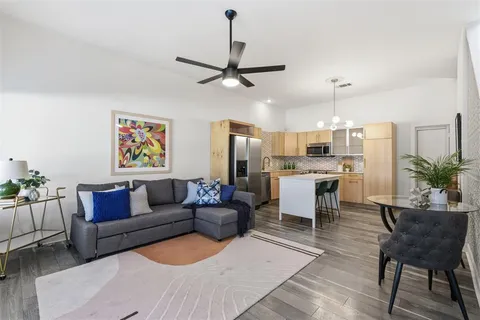 a living room with furniture kitchen view and a chandelier