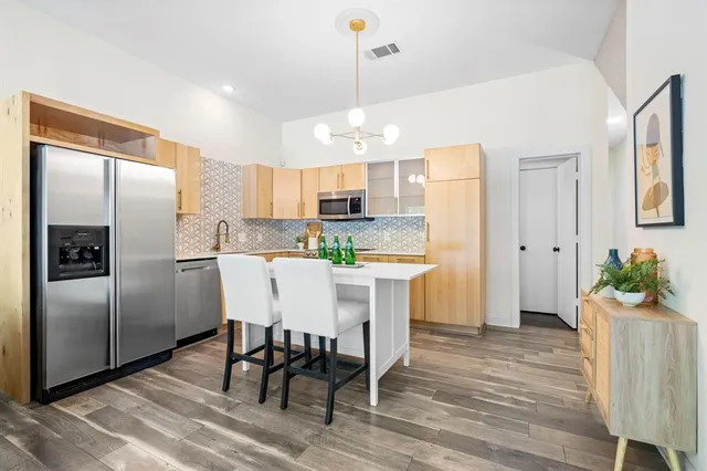 a kitchen with kitchen island white cabinets and stainless steel appliances