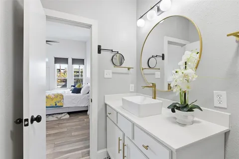 a en suite bathroom with a granite countertop sink and a mirror