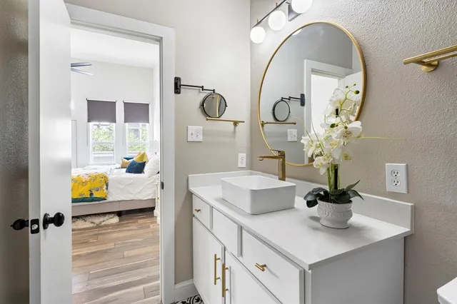 a bathroom with a granite countertop sink a mirror and vanity