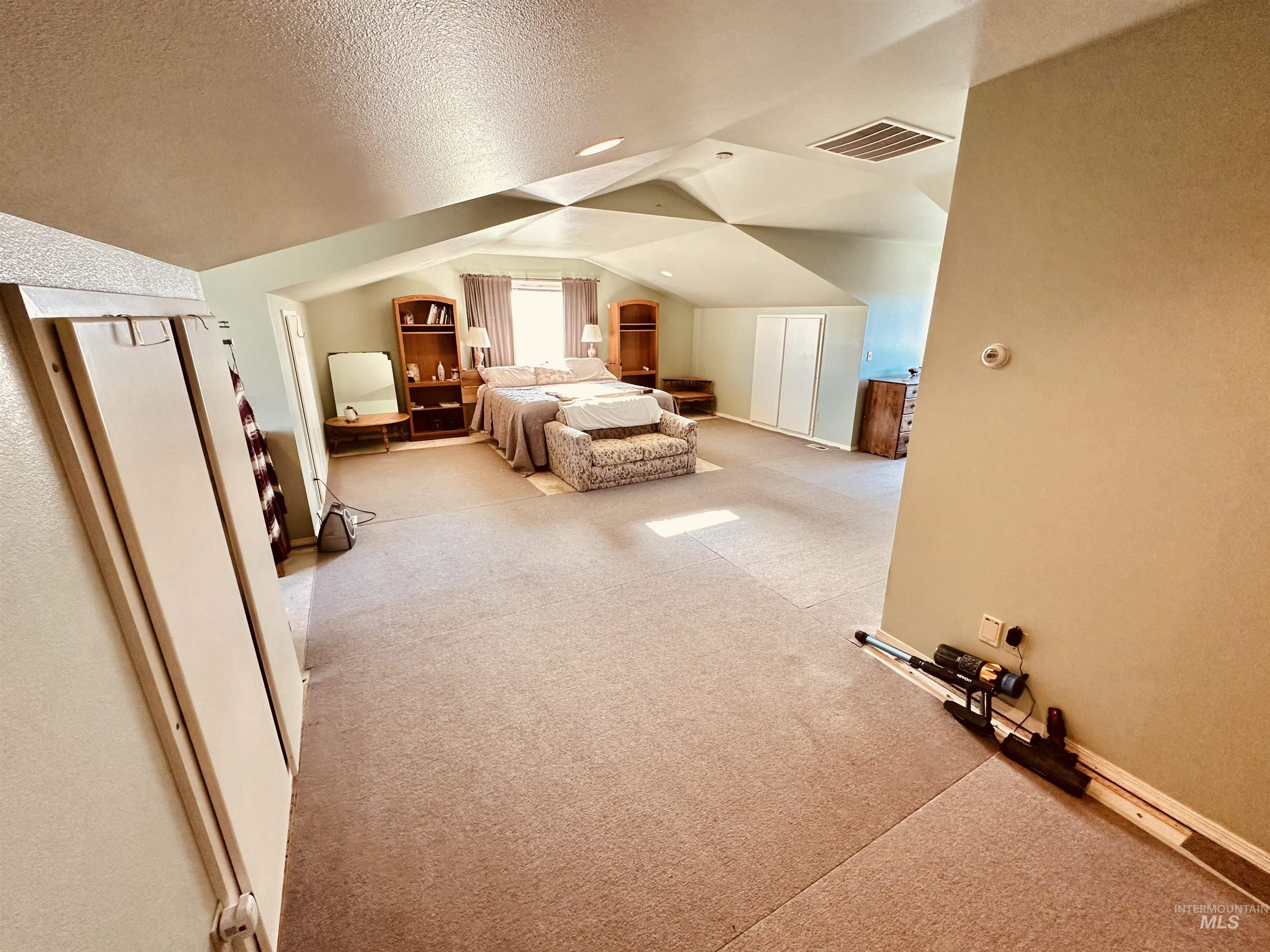 1049 Grand Avenue Nyssa, OR 97913 - Photo 16 of 50 Spacious room featuring sloped ceilings, recessed lighting, carpet flooring, a window with natural light, and bi-fold closet doors