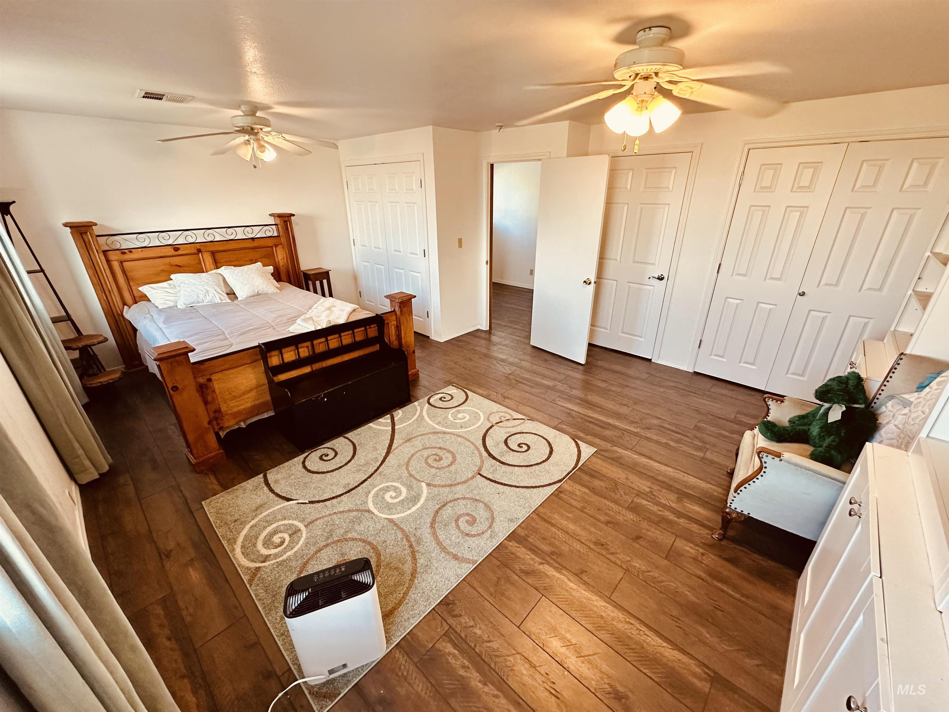 1049 Grand Avenue Nyssa, OR 97913 - Photo 26 of 50 Spacious room featuring wood-finish flooring, two ceiling fans with integrated lighting, and multiple paneled doors