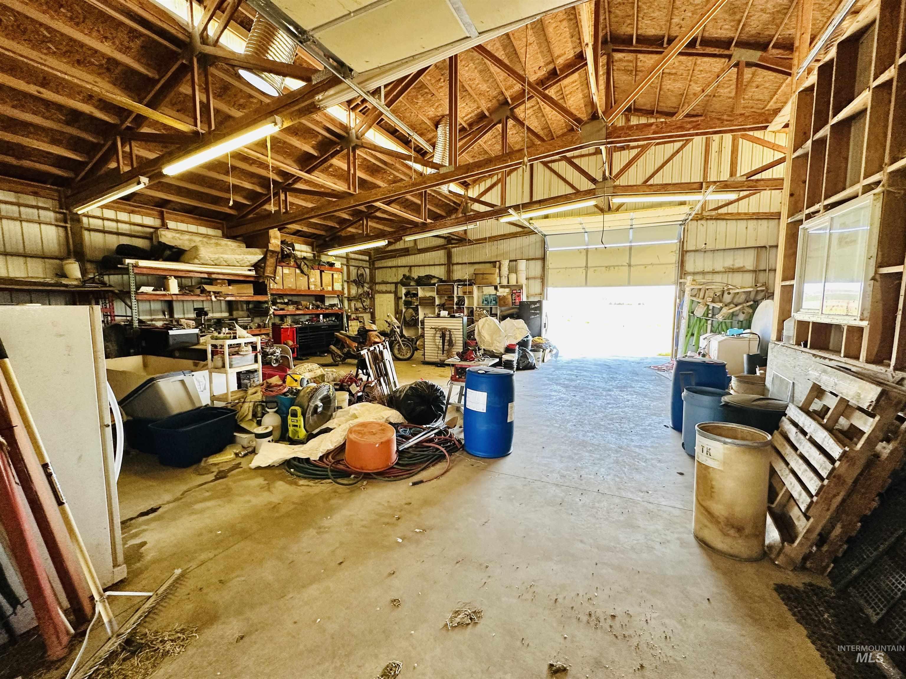 1049 Grand Avenue Nyssa, OR 97913 - Photo 37 of 50 Spacious garage interior featuring high vaulted wood ceilings, exposed wood beams, and a concrete floor