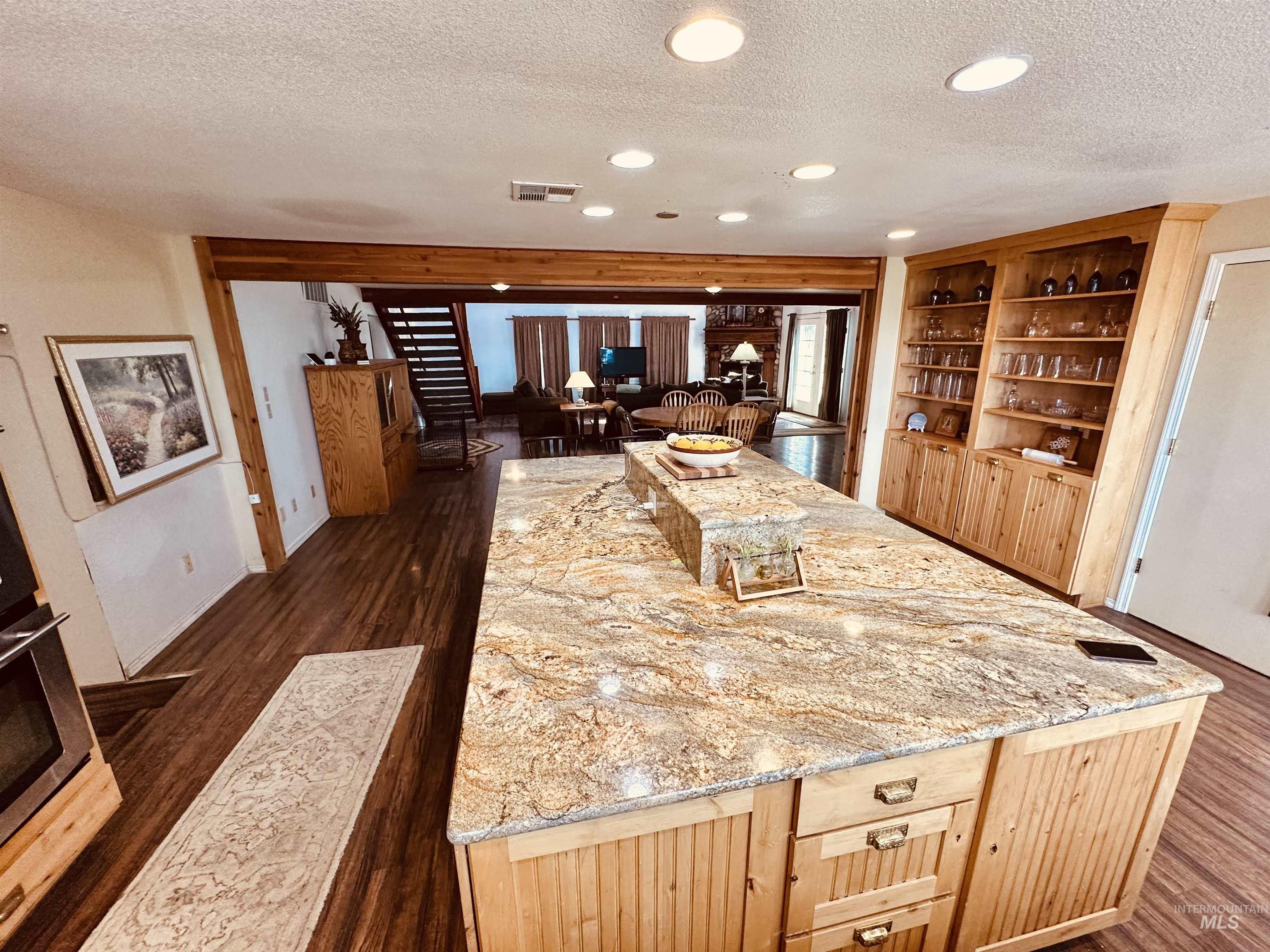 1049 Grand Avenue Nyssa, OR 97913 - Photo 7 of 50 Kitchen island featuring a granite countertop with a tiered section, beadboard paneling, and integrated drawers