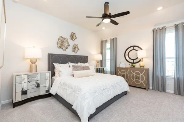 a bedroom with a bed a mirror and a lamp on dresser