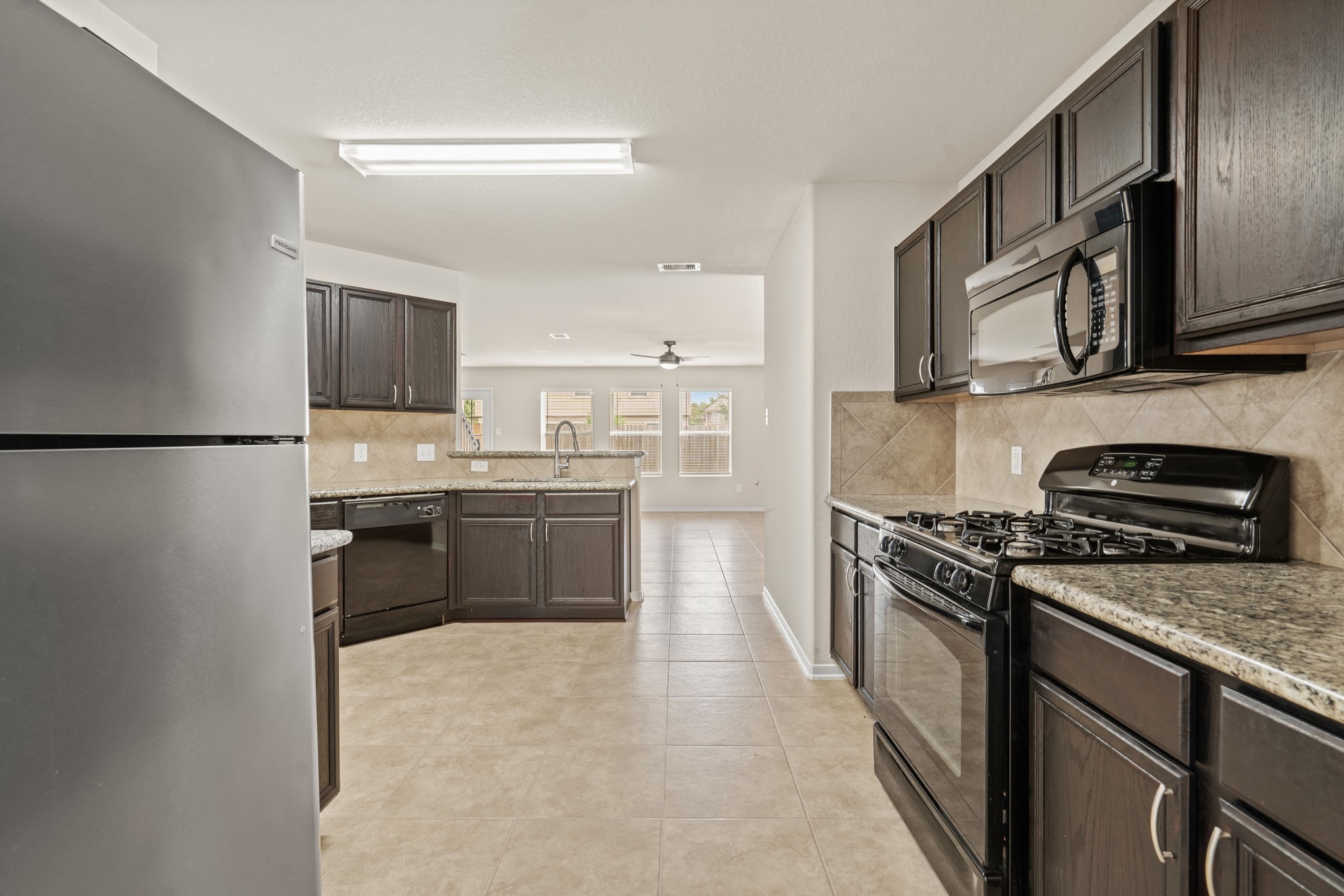 3118 Winchester Rnch Trail Katy, TX 77493 - Photo 19 of 36 a kitchen with stainless steel appliances granite countertop a stove top oven a sink and a refrigerator
