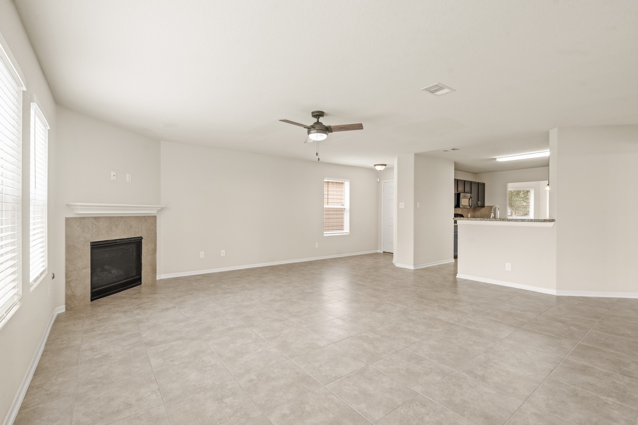 3118 Winchester Rnch Trail Katy, TX 77493 - Photo 10 of 36 an empty room with a kitchen and a fireplace