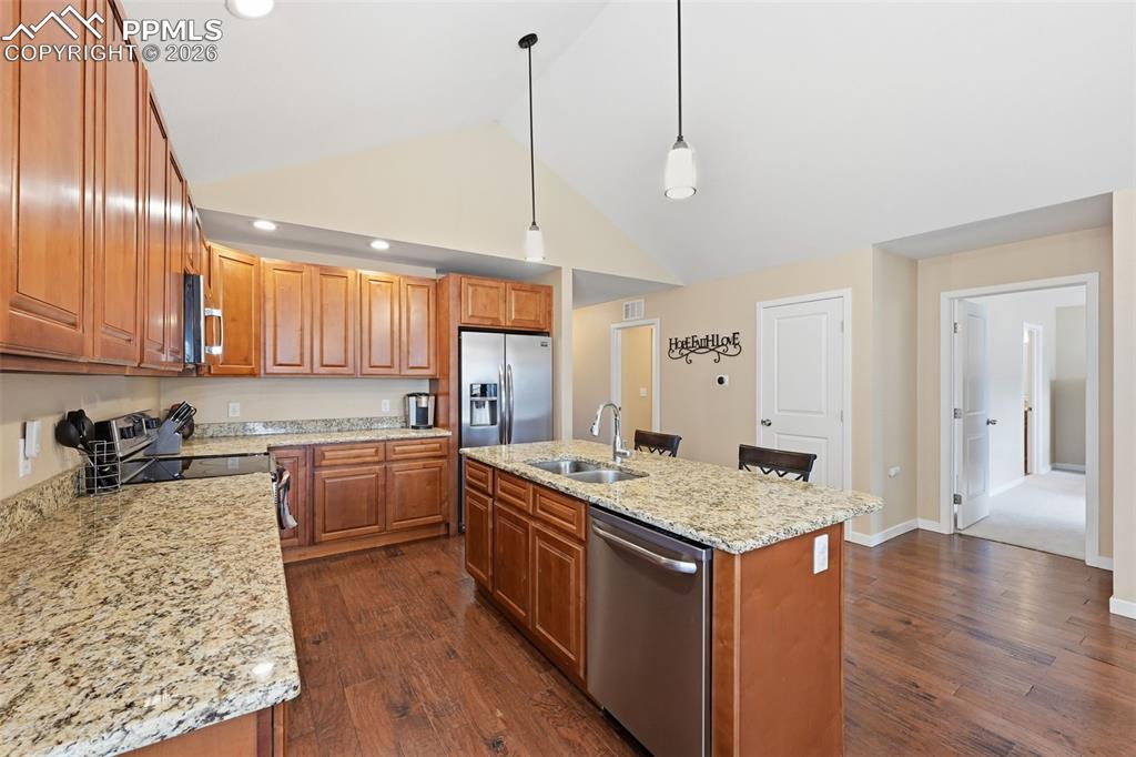 6565 Watusi Road Peyton, CO 80831 - Photo 11 of 36 a kitchen with stainless steel appliances granite countertop a sink stove and refrigerator