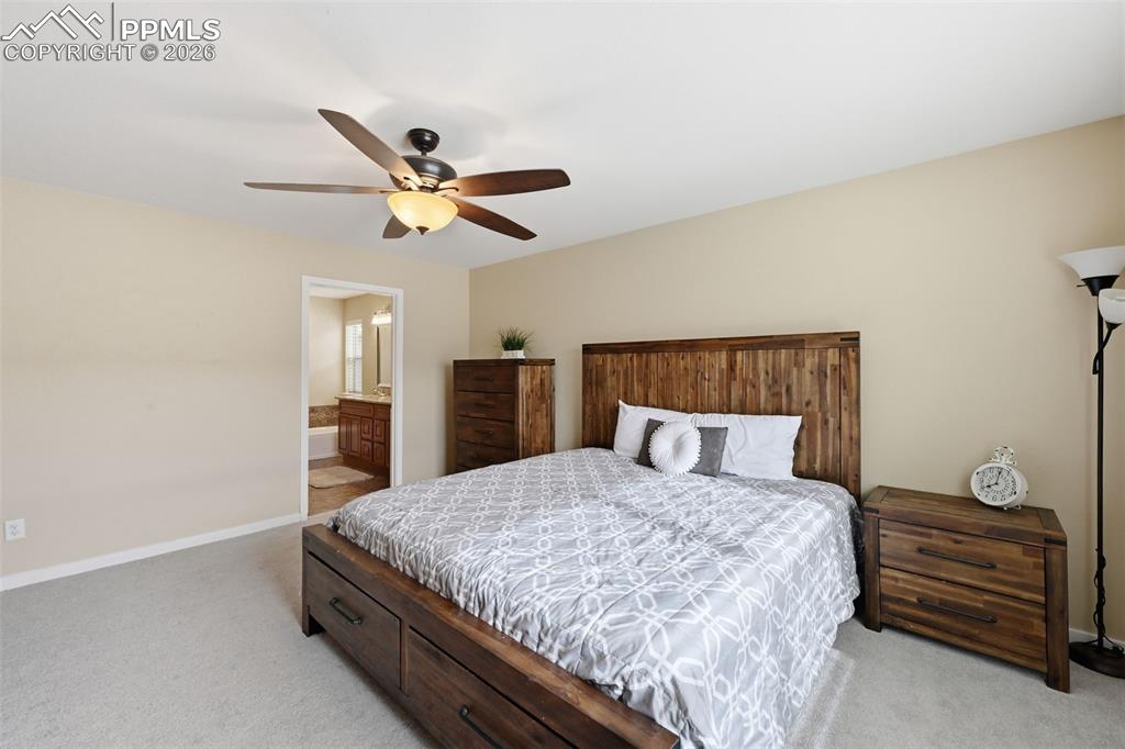 6565 Watusi Road Peyton, CO 80831 - Photo 20 of 36 a bedroom with a bed and a chandelier