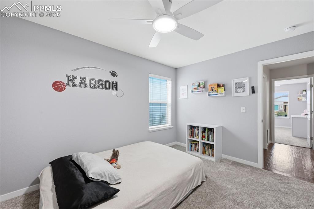 6565 Watusi Road Peyton, CO 80831 - Photo 25 of 36 a bedroom with a bed and a chandelier
