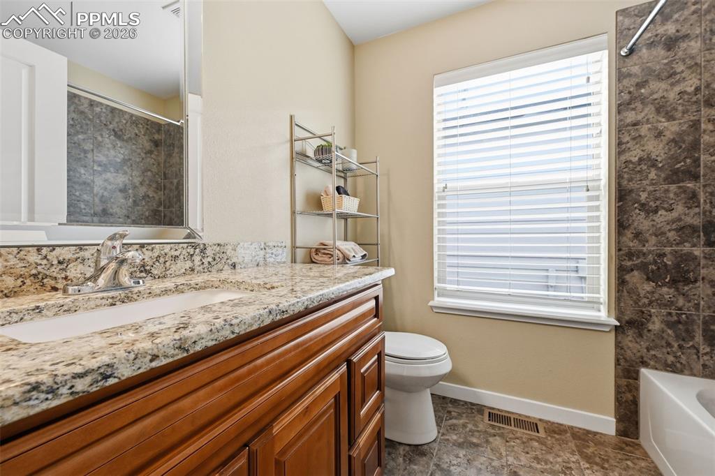 6565 Watusi Road Peyton, CO 80831 - Photo 27 of 36 a bathroom with a granite countertop sink toilet and shower