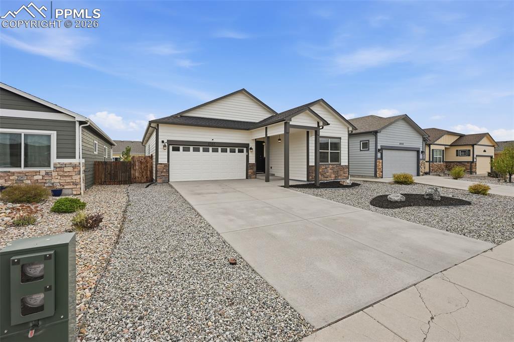 6565 Watusi Road Peyton, CO 80831 - Photo 3 of 36 a front view of a house with a yard and garage