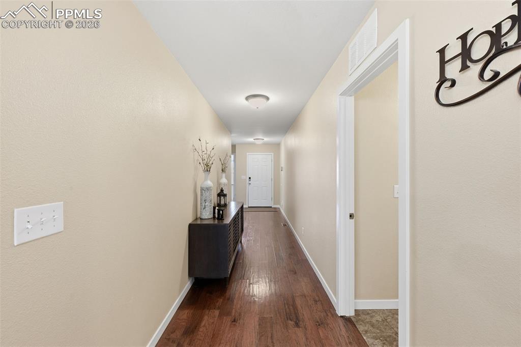 6565 Watusi Road Peyton, CO 80831 - Photo 8 of 36 a view of a hallway with wooden floor and stairs