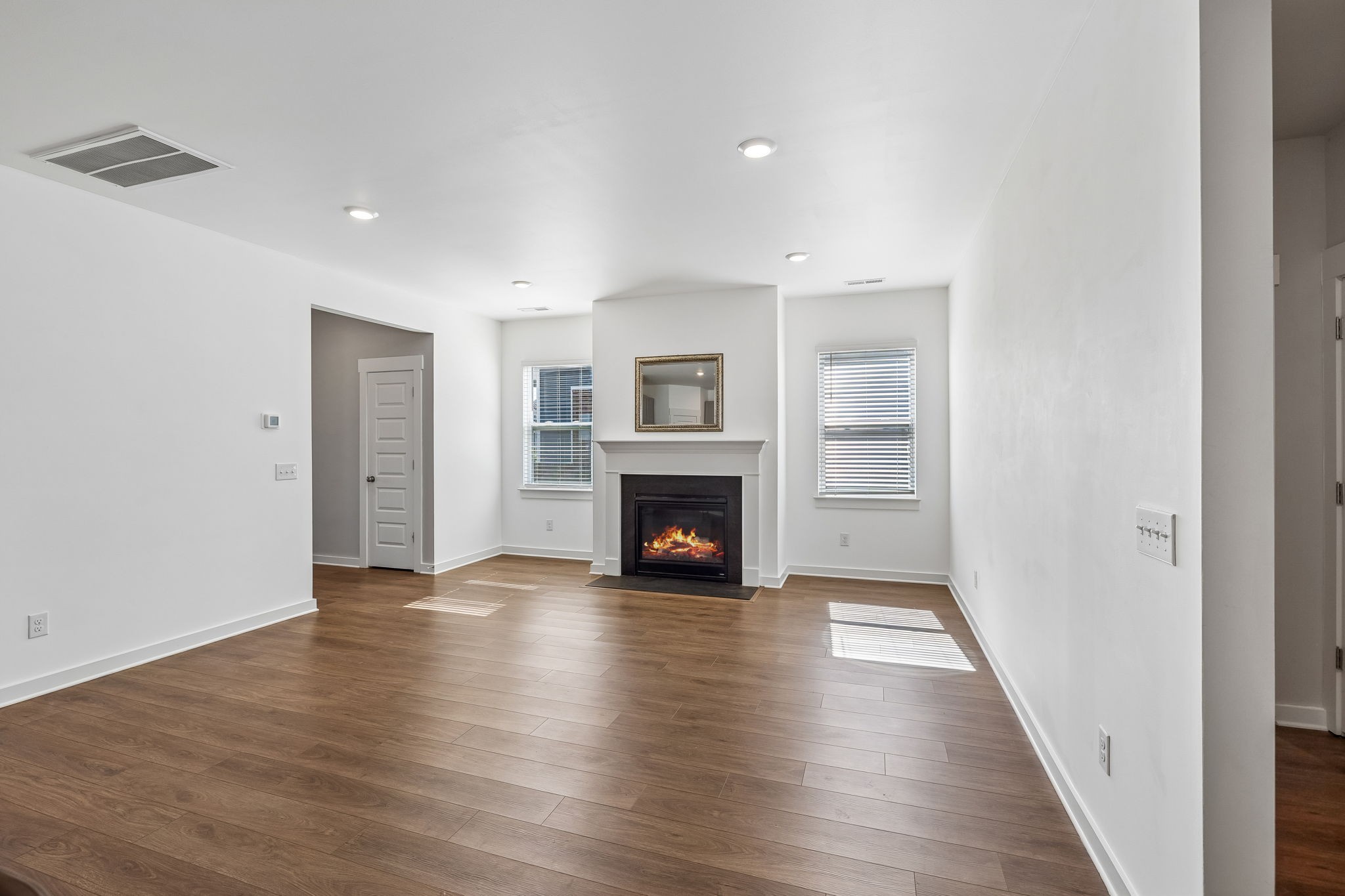 167 Harvest Point Boulevard Spring Hill, TN 37174 - Photo 12 of 55 a view of an empty room with wooden floor fireplace and a window
