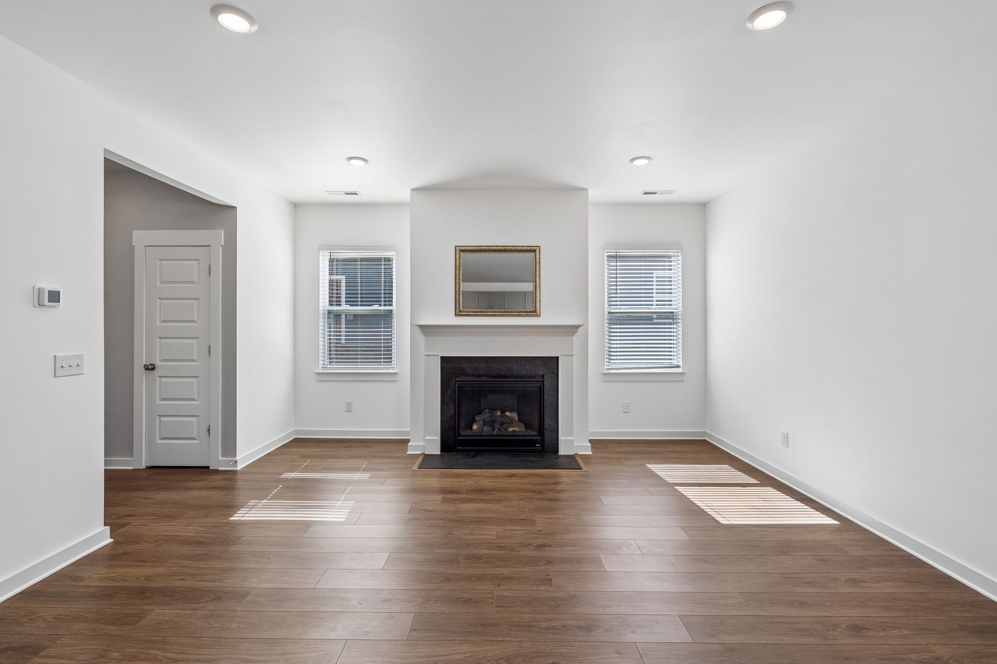 167 Harvest Point Boulevard Spring Hill, TN 37174 - Photo 13 of 55 an empty room with wooden floor fireplace and windows