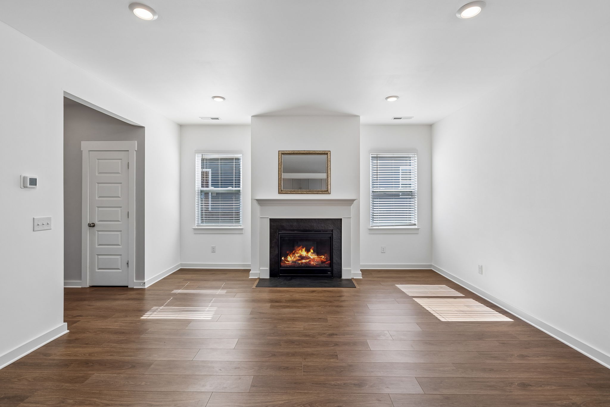 167 Harvest Point Boulevard Spring Hill, TN 37174 - Photo 14 of 55 an empty room with wooden floor fireplace and windows