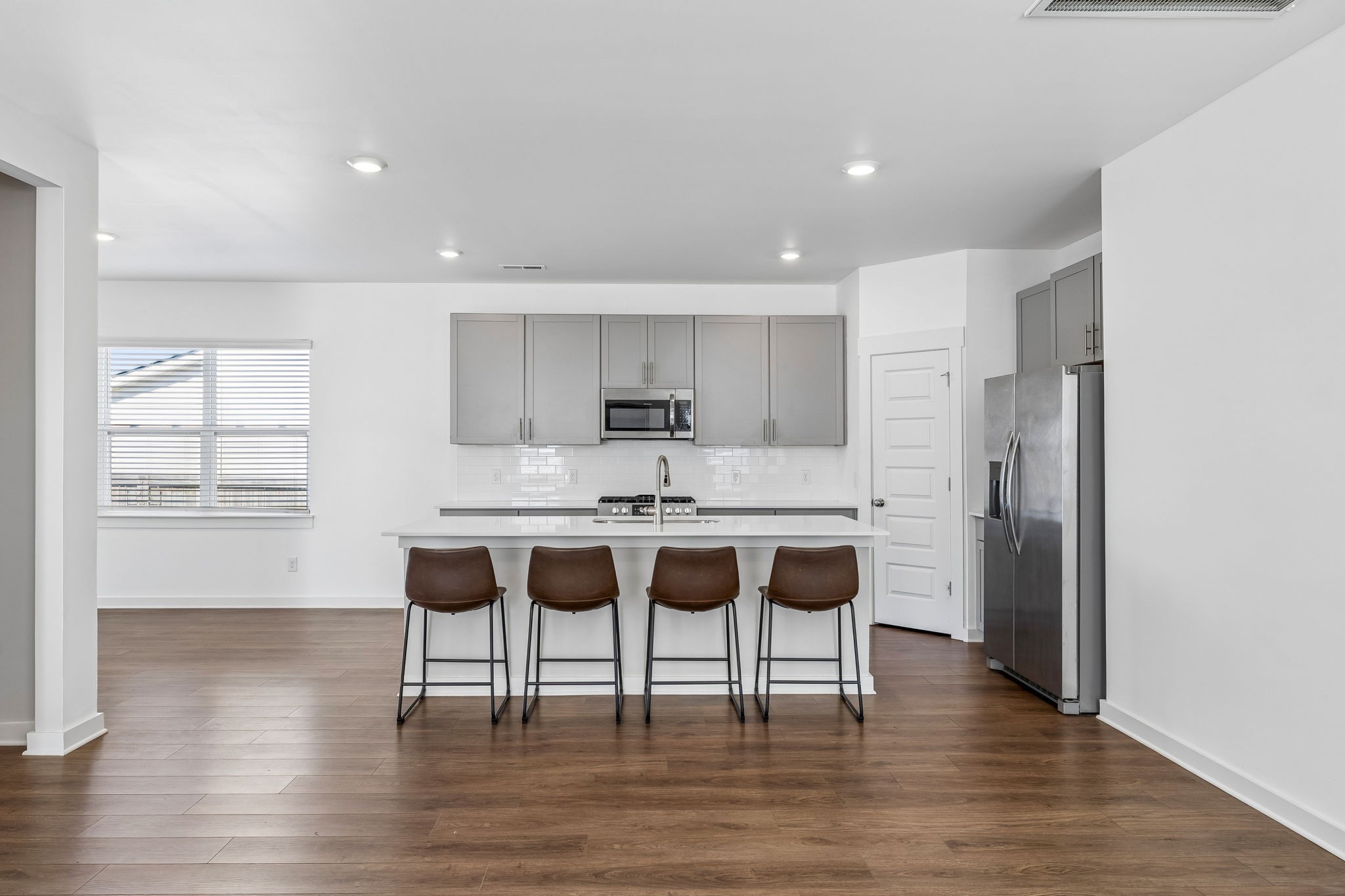 167 Harvest Point Boulevard Spring Hill, TN 37174 - Photo 16 of 55 a kitchen with a dining table chairs refrigerator and cabinets