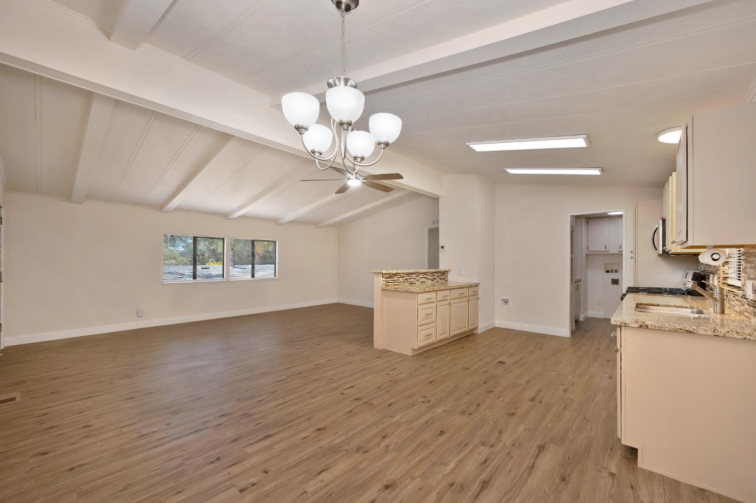 4420 Pleasant Valley Road, Unit 105 Diamond Springs, CA 95619 - Photo 16 of 33 a view of a kitchen with a sink stainless steel appliances and a chandelier