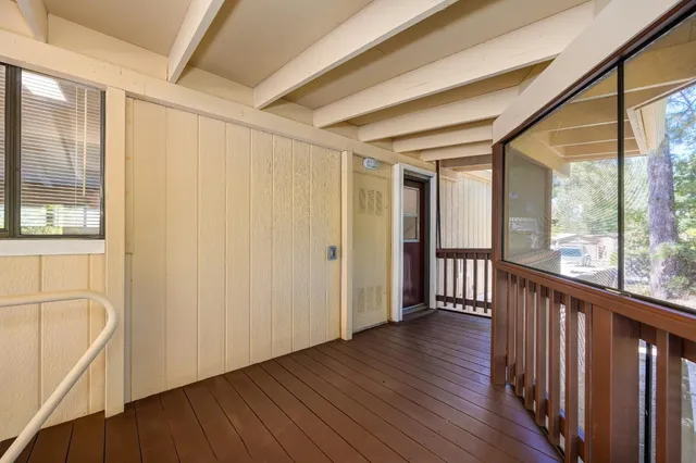 a view of a hallway with wooden floor and windows