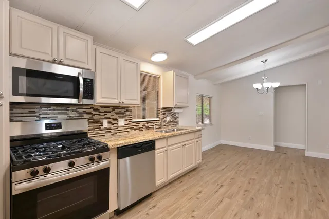 a kitchen with appliances a sink and cabinets