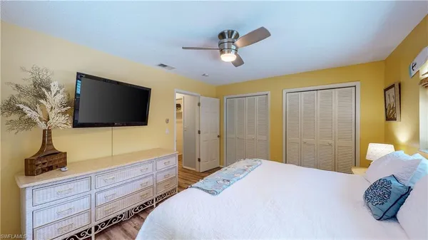 a bedroom with a large bed and wooden floor