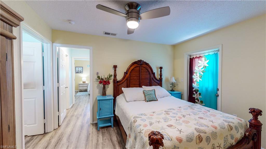 509 Shore Road Nokomis, FL 34275 - Photo 19 of 50 a bedroom with a large bed and wooden floor
