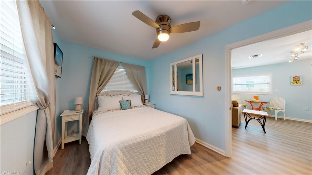 509 Shore Road Nokomis, FL 34275 - Photo 31 of 50 a bedroom with a bed and a table in it with wooden floor