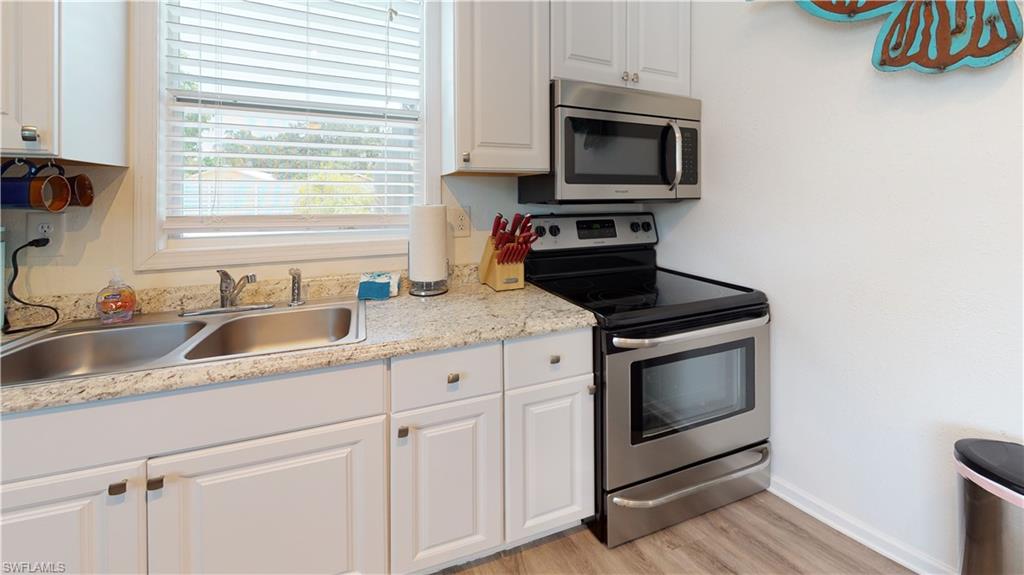 509 Shore Road Nokomis, FL 34275 - Photo 34 of 50 a kitchen with granite countertop white cabinets stainless steel appliances and a sink
