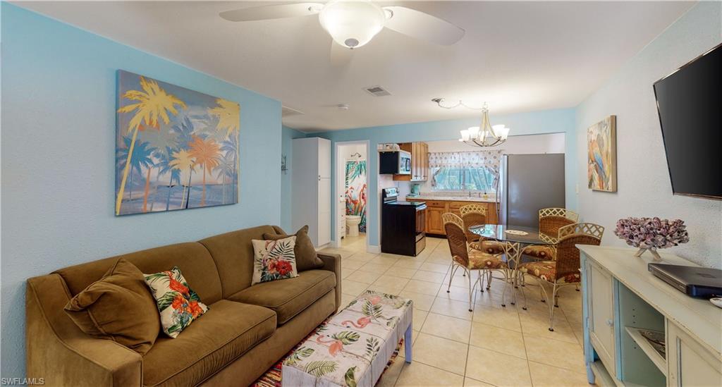 509 Shore Road Nokomis, FL 34275 - Photo 37 of 50 a living room with furniture a dining table and a flat screen tv