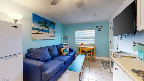 a living room with patio furniture and a floor to ceiling window
