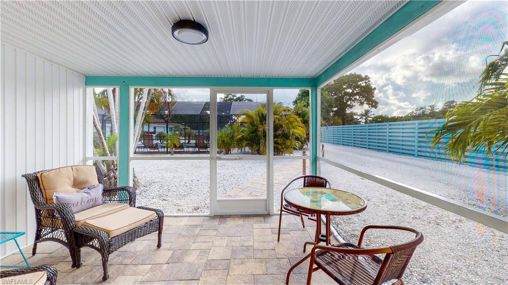 509 Shore Road Nokomis, FL 34275 - Photo 45 of 50 a living room with patio furniture and a floor to ceiling window
