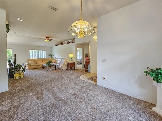 a view of a livingroom with furniture furniture wooden floor and a chandelier