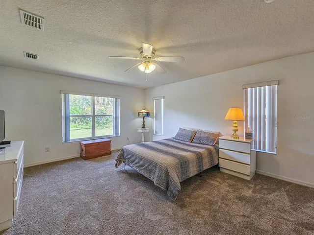 a spacious bedroom with a bed and a window