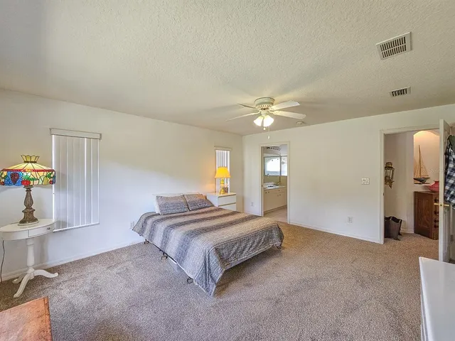 a spacious bedroom with a bed and a chandelier
