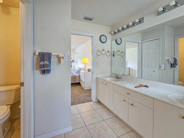 a spacious bathroom with a granite countertop sink and a mirror
