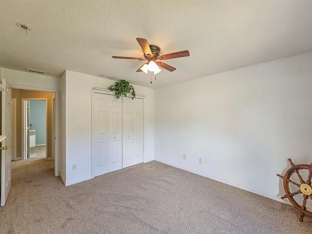 a view of a livingroom with a ceiling fan and carpet