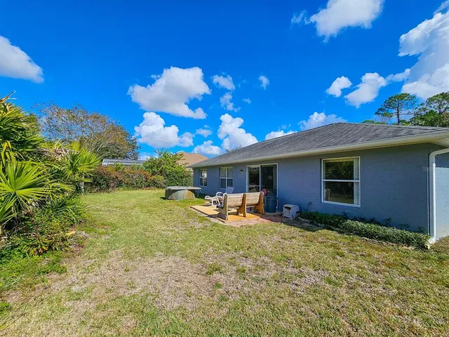 a view of a house with backyard and sitting area