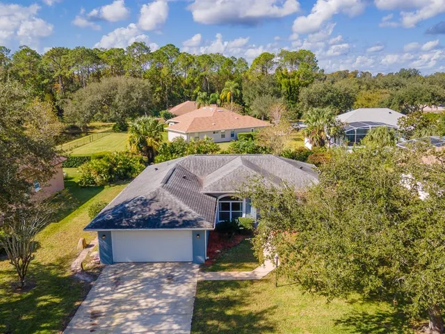 an aerial view of a house with a garden and lake view