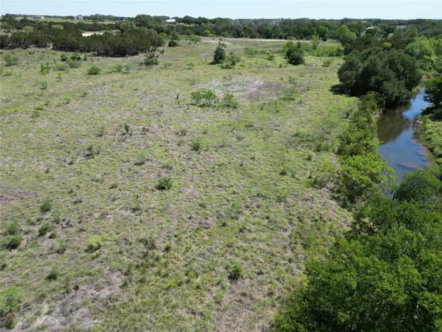 a view of a field with trees in the background