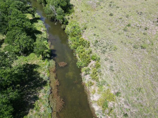 an aerial view of residential houses with outdoor space and trees